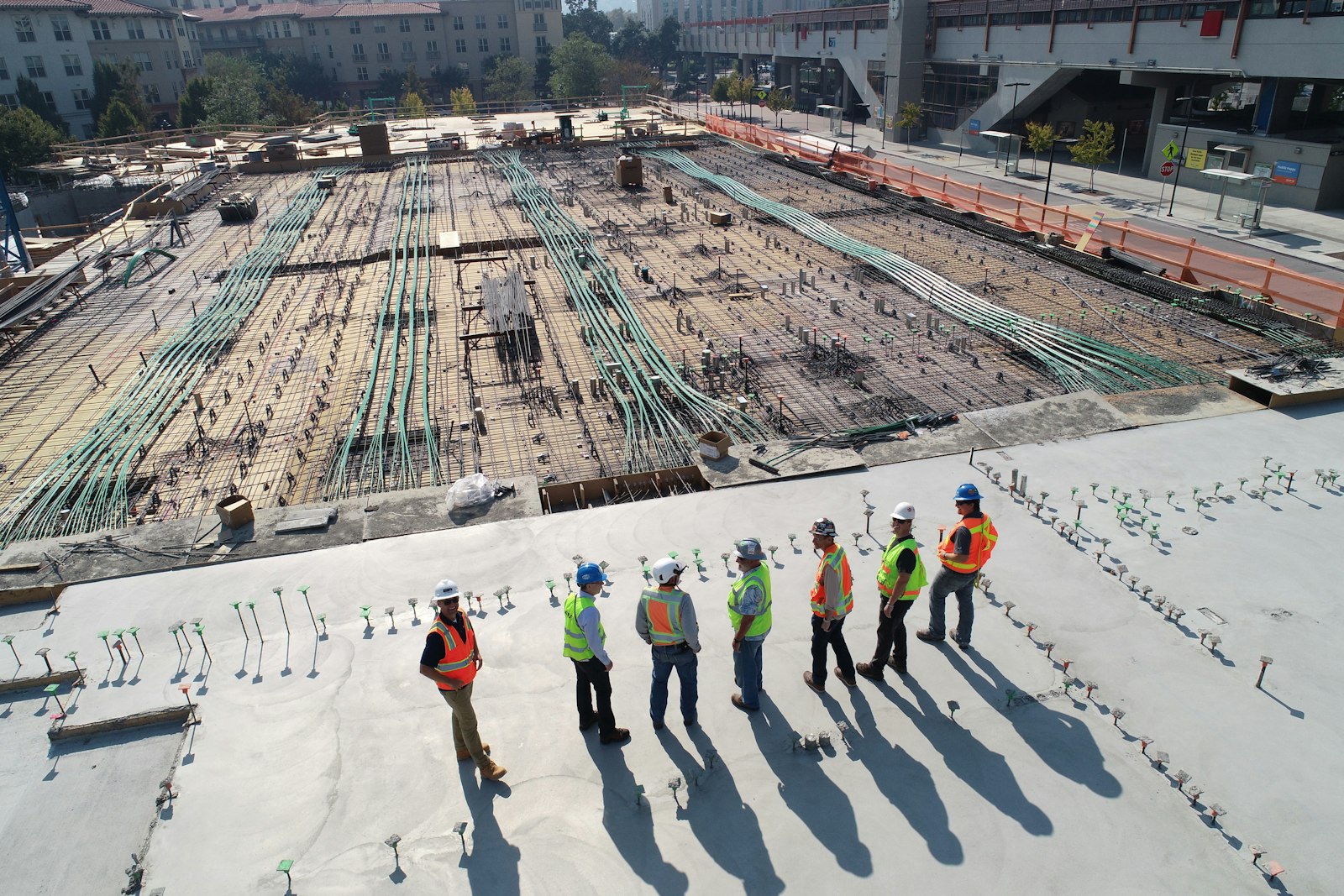 Construction crew in hi-vis vests meeting on a large commercial building site