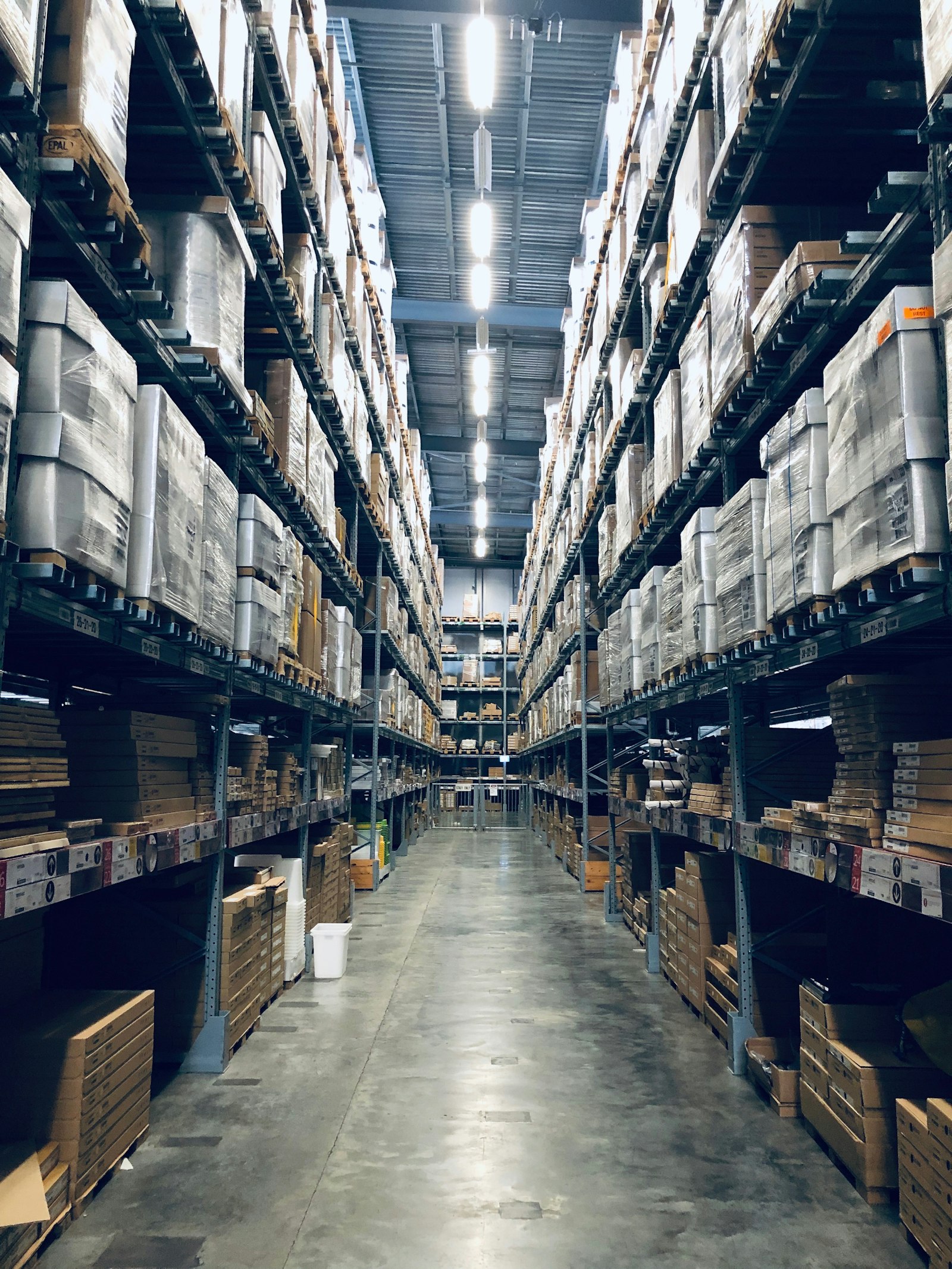 Long aisle of stocked racking inside a large warehouse